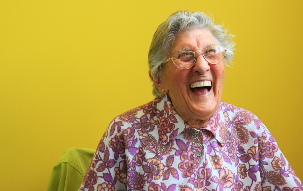 An elderly woman laughing.