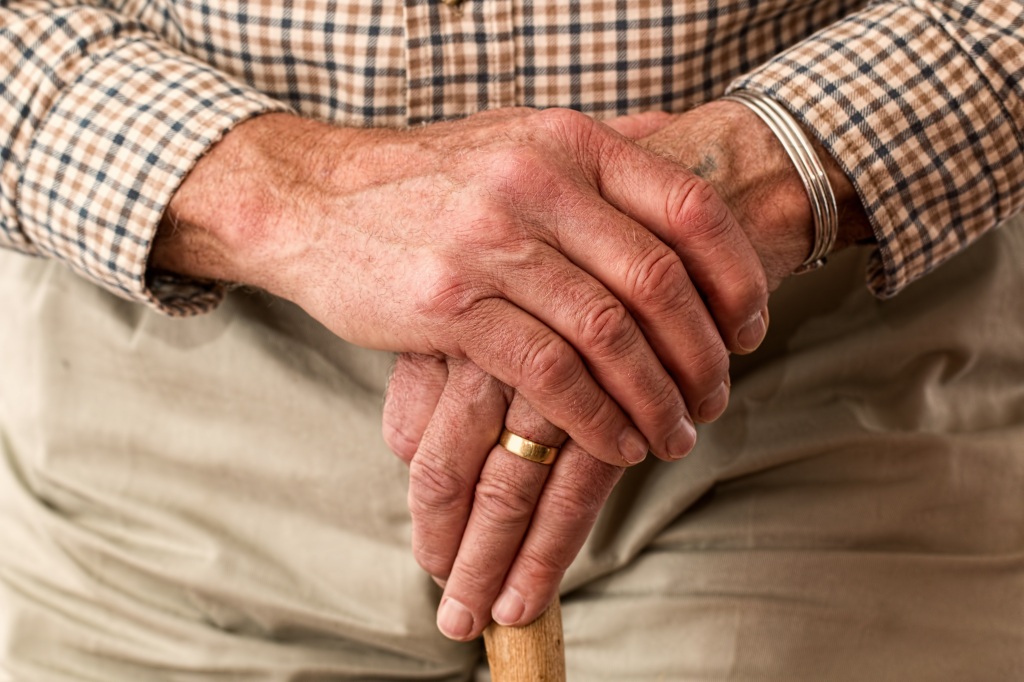 A picture of an elderly man holding a cane.